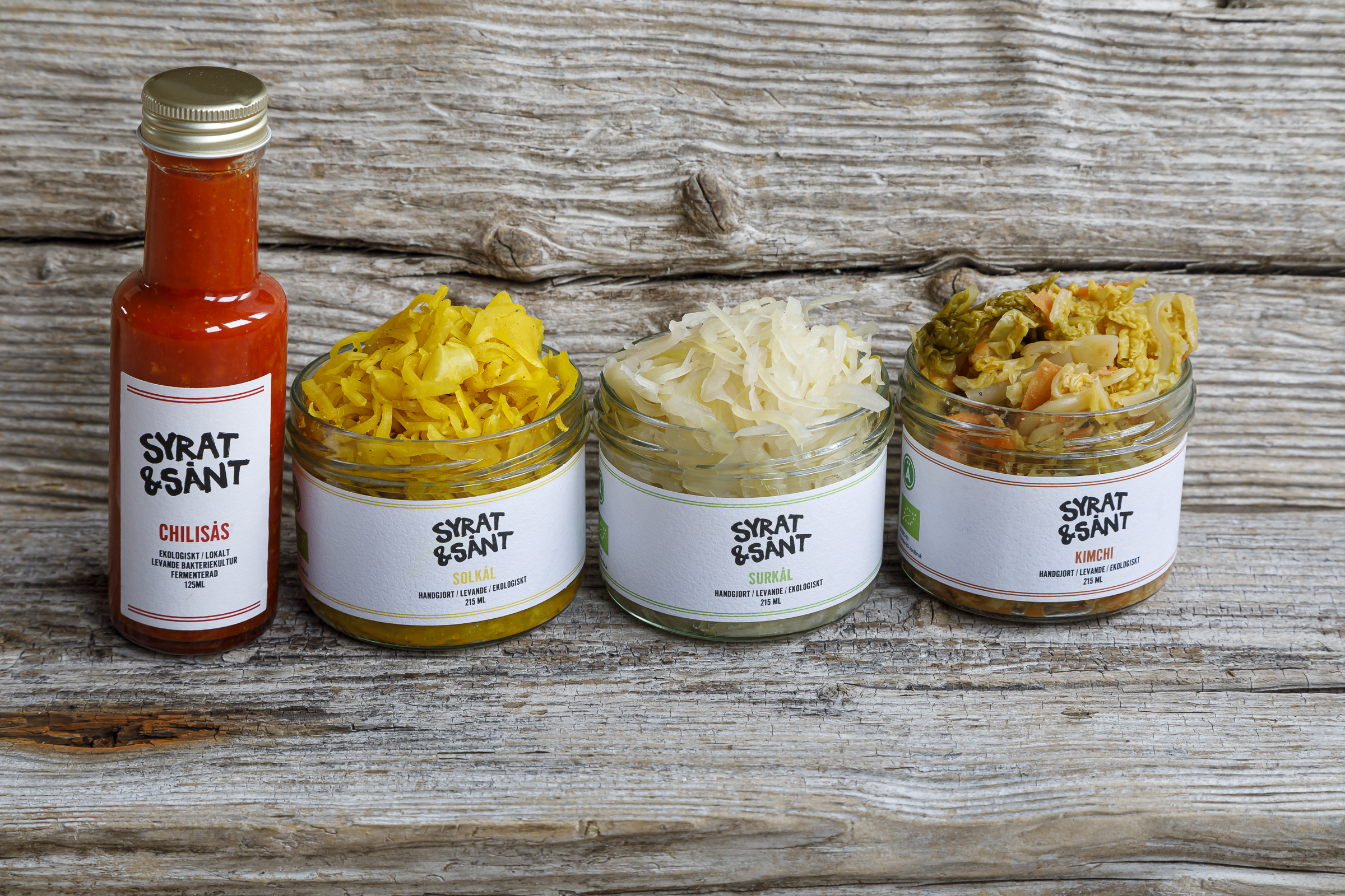 syrat och sånt, kimche, syrad vitkål, chilisås burkar av produkter på en träplanka